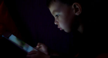 Cute kid with tablet in the dark.